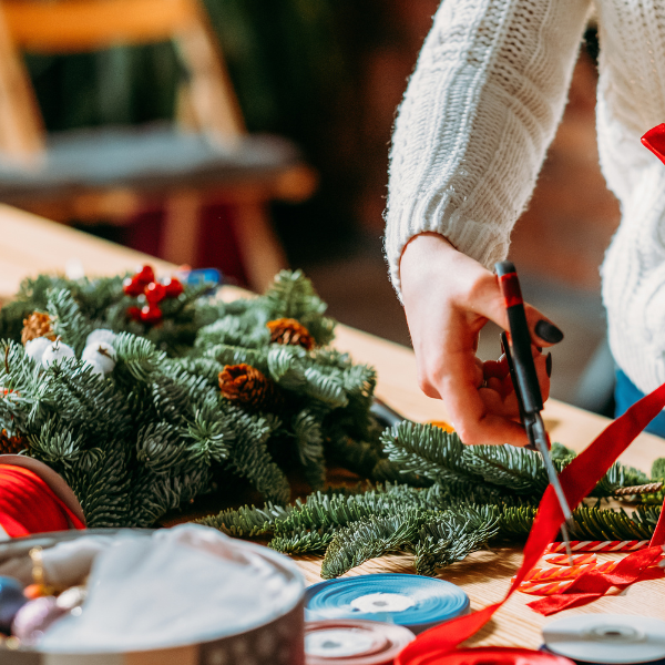 woman crafting Christmas wreath
